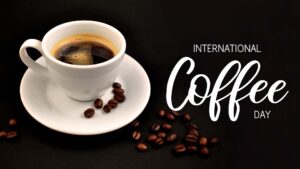 Międzynarodowy dzień kawy wpis na bloga -zdjęcie ilustracyjne przedstawia filiżankę kawy z ziarenkami na spodku. Obok napis international coffee day
