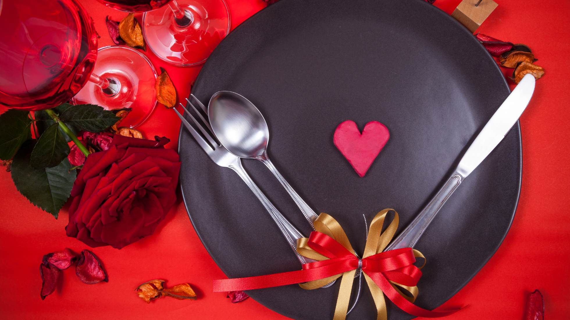 Zdjęcie ilustracyjne wpisu na bloga kolacja walentynkowa przedstawia talerz na czerwonym obrusie. Na środku talerza serce
