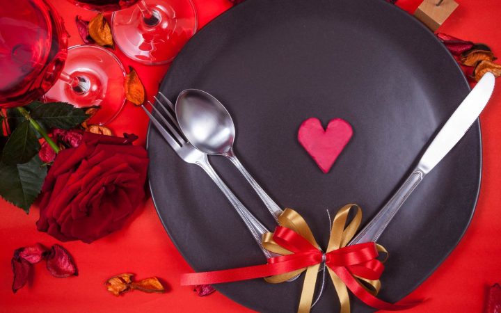 Zdjęcie ilustracyjne wpisu na bloga kolacja walentynkowa przedstawia talerz na czerwonym obrusie. Na środku talerza serce