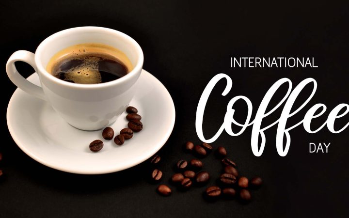 Międzynarodowy dzień kawy wpis na bloga -zdjęcie ilustracyjne przedstawia filiżankę kawy z ziarenkami na spodku. Obok napis international coffee day